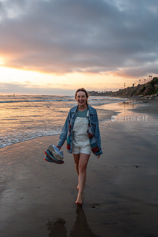 一个女孩走在加州恩西尼塔斯的圣伊莱霍海滩上
