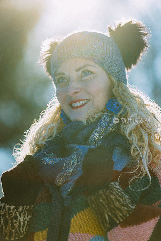 幸福的女人在冬天森林附近的白雪皑皑的草地