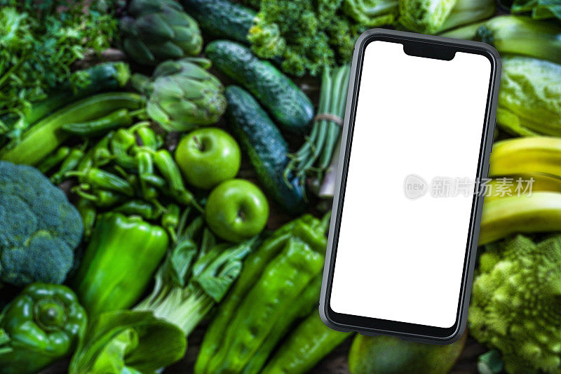手机以绿色果蔬为背景，屏幕空白。本空间