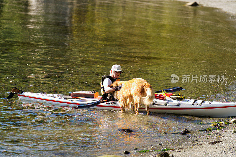 皮划艇者受到他的狗的欢迎