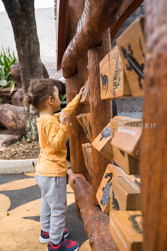 小男孩在蒙台梭利幼儿园玩木制的圆筒玩具