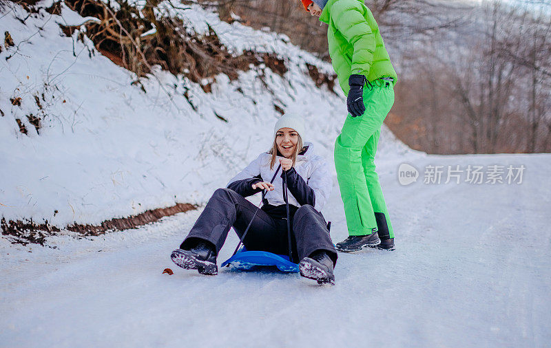 一对夫妇在冬天一起在雪地上滑行