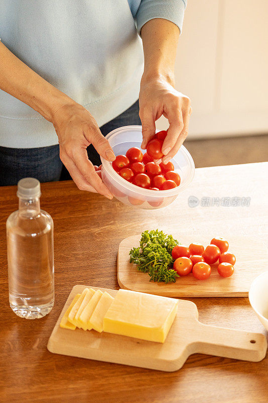 妇女用塑料容器收集食物