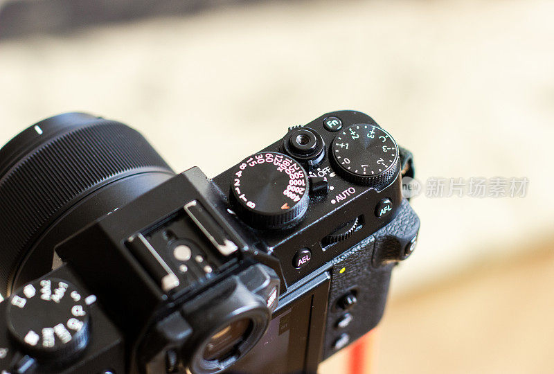 黑色复古设计的相机安装在三脚架上，用于拍摄照片或视频。相机上的轮子用于设置。