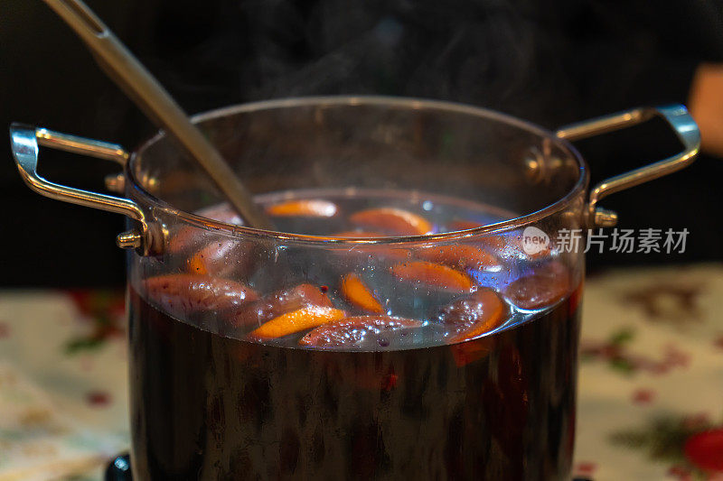 户外集市和节日上，一个大玻璃锅里盛着由水果和浆果制成的辛辣热酒