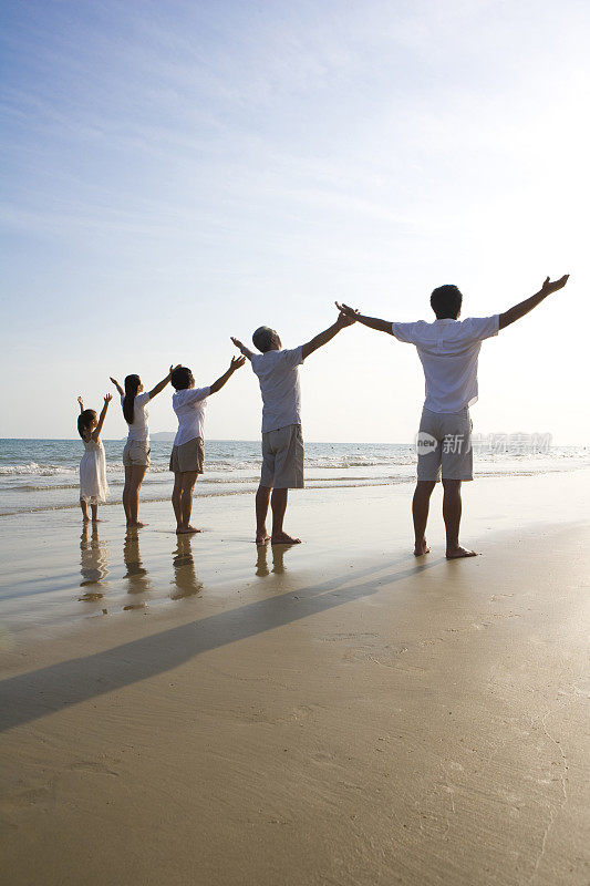 全家人在沙滩上张开双臂