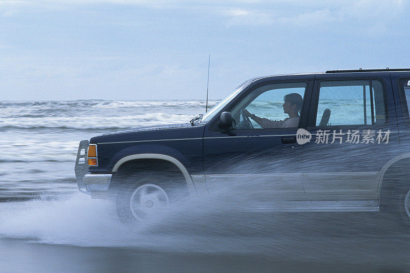 一辆在海边行驶的休闲车，侧视图