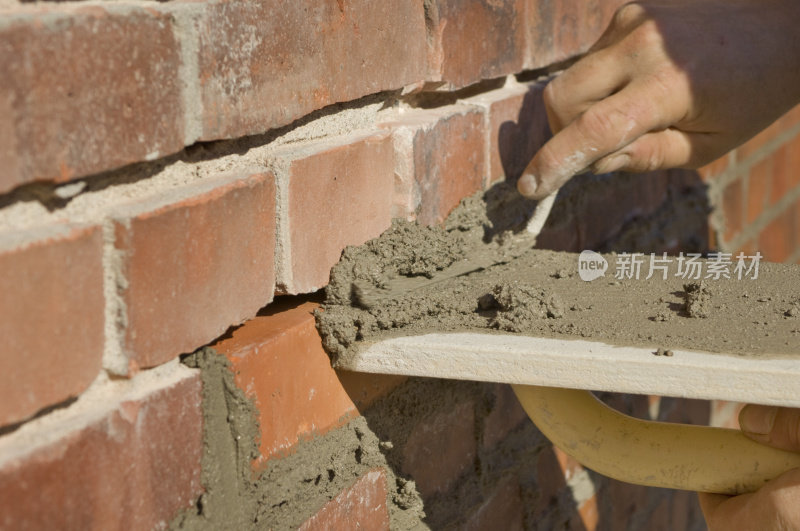 建筑工人用新水泥重新浇筑旧砖块