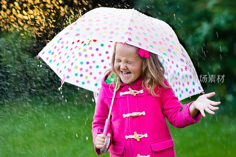 小女孩撑着伞在雨中走