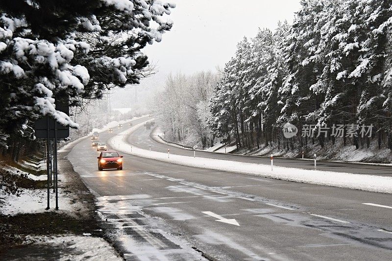 汽车在冬天的雪地上行驶。恶劣天气下的交通十分危险