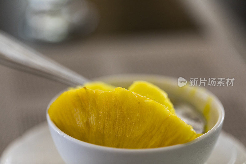 特写镜头新鲜的菠萝冰沙与一片菠萝在碗。