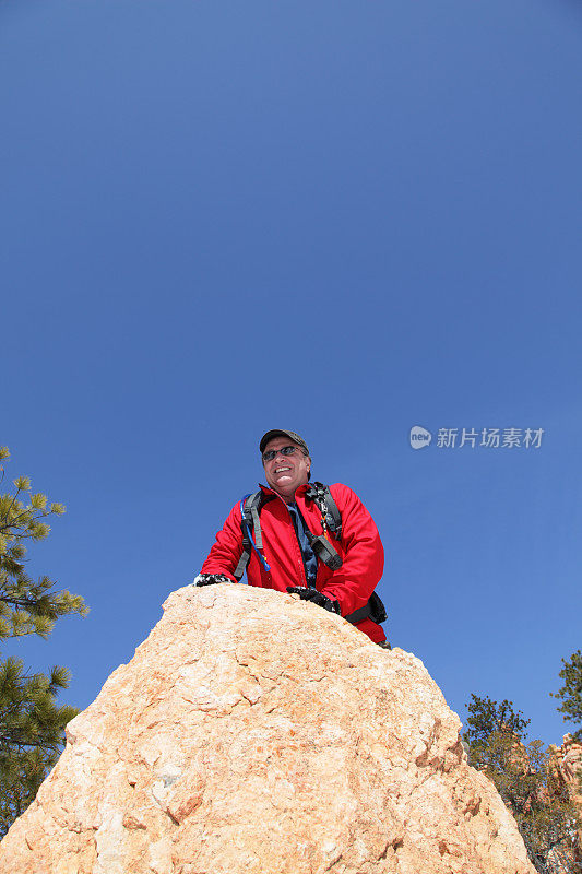 徒步旅行者爬到岩石的顶端