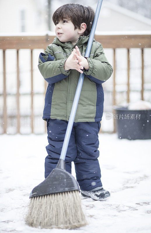 小男孩在清理桌子上的雪