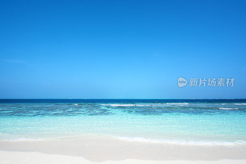 热带海滩和绿色泻湖与蓝天背景
