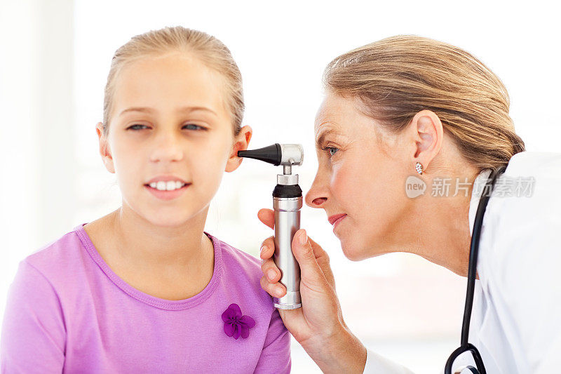 医生用耳镜分析小女孩的耳朵