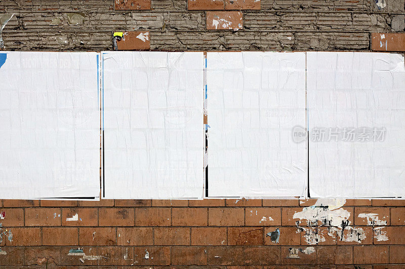 四块真正的空白广告牌挂在一堵破旧的墙上