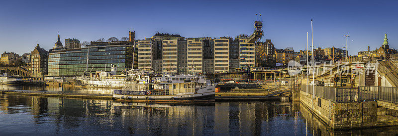 斯德哥尔摩金色的日出阳光在Sodermalm海港海滨全景瑞典