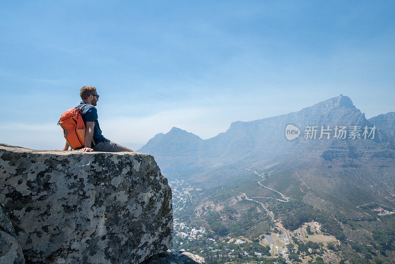 一个年轻人在开普敦山顶上看风景