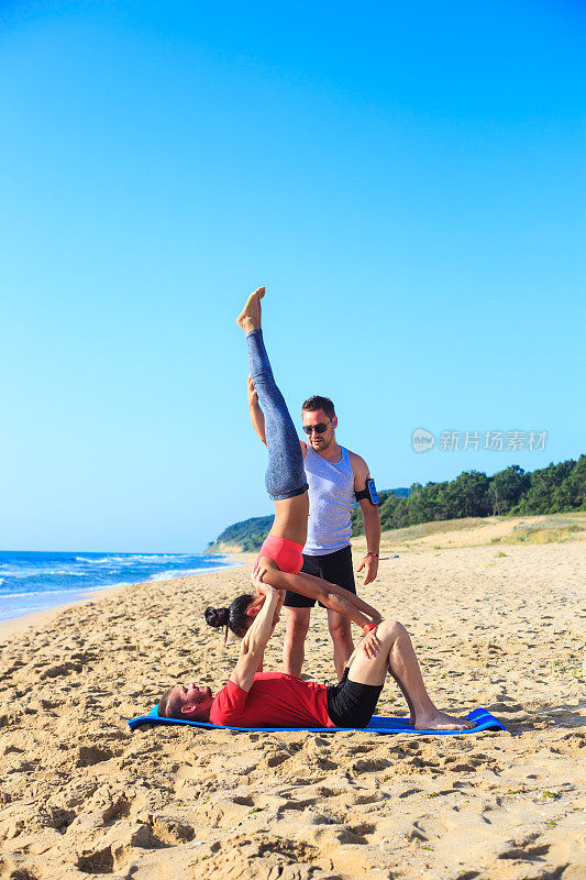 在海滩上集体练习acro瑜伽