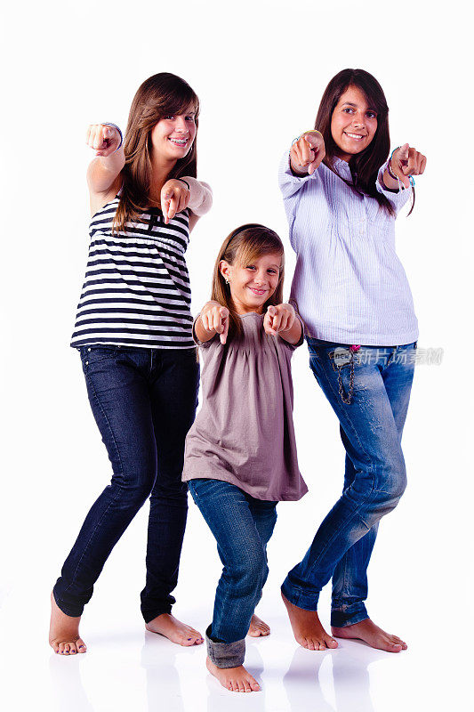 三个快乐的少女姐妹指着相机