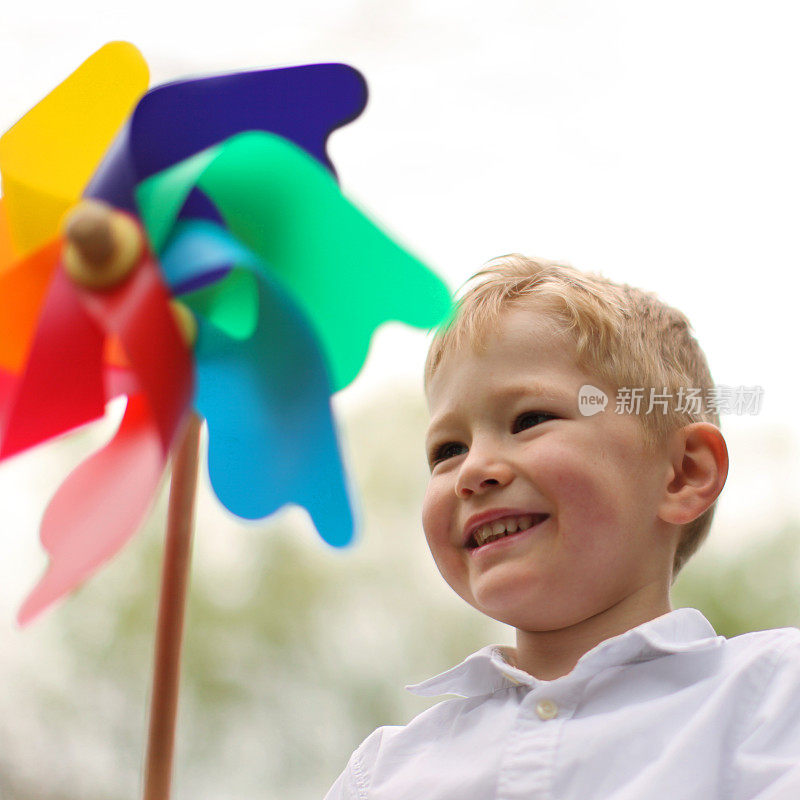 微笑的小男孩玩风车