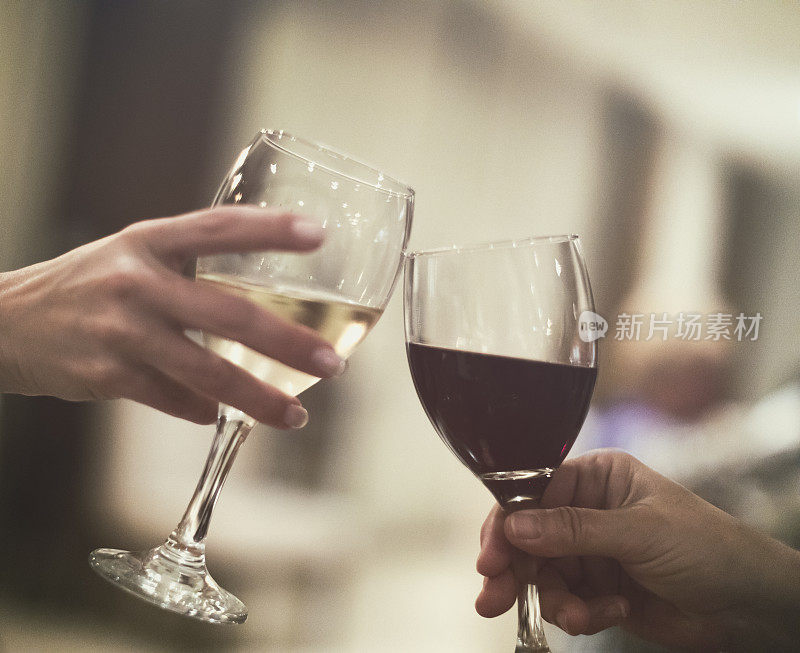 两名妇女一边庆祝好消息一边喝着红酒和白葡萄酒。