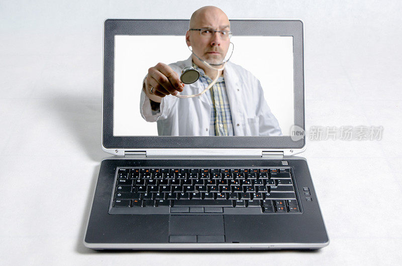 笔记本电脑和一个拿着听诊器的男医生在他面前