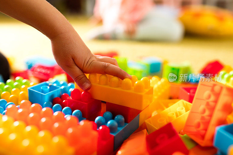 一个孩子用玩具积木做东西的手。