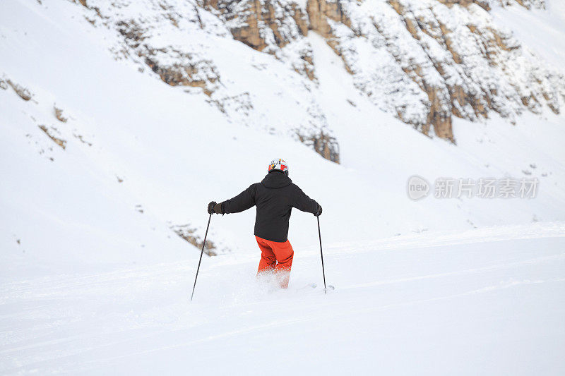 后视图男人在乡间滑雪，雪上有粉