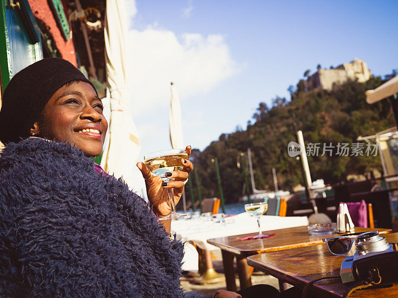 年轻的非洲女人坐在路边的咖啡馆里