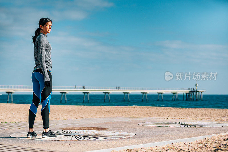 年轻女子在沙滩上慢跑后休息