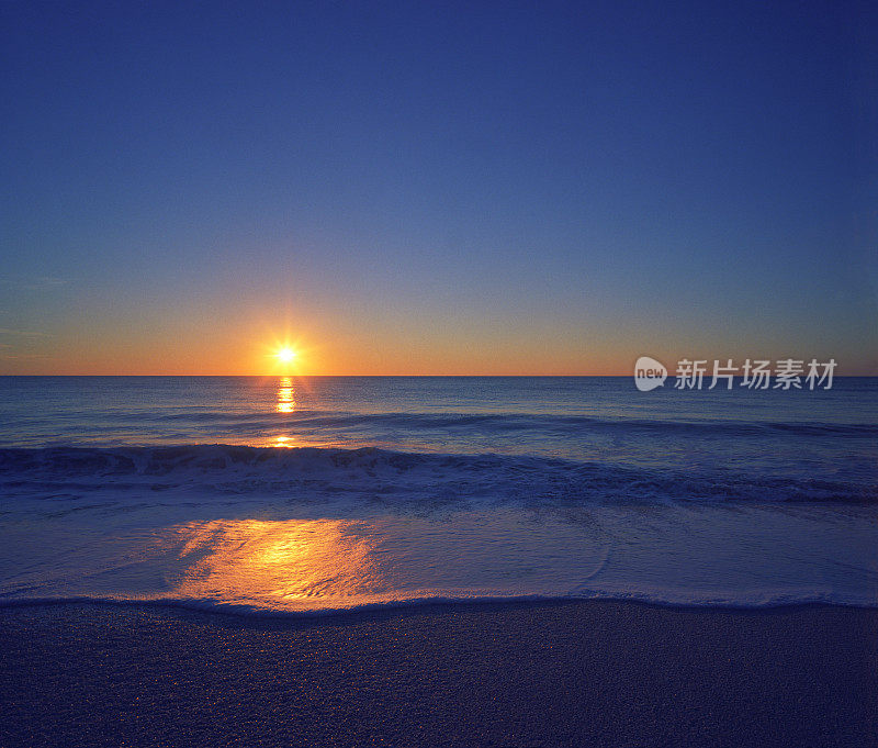 日落和海滩上的平静海浪