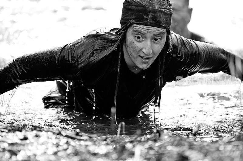 女人爬出了水，在泥跑障碍
