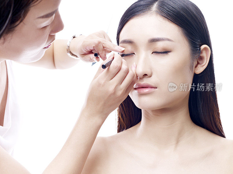 化妆师在年轻的亚洲女模特