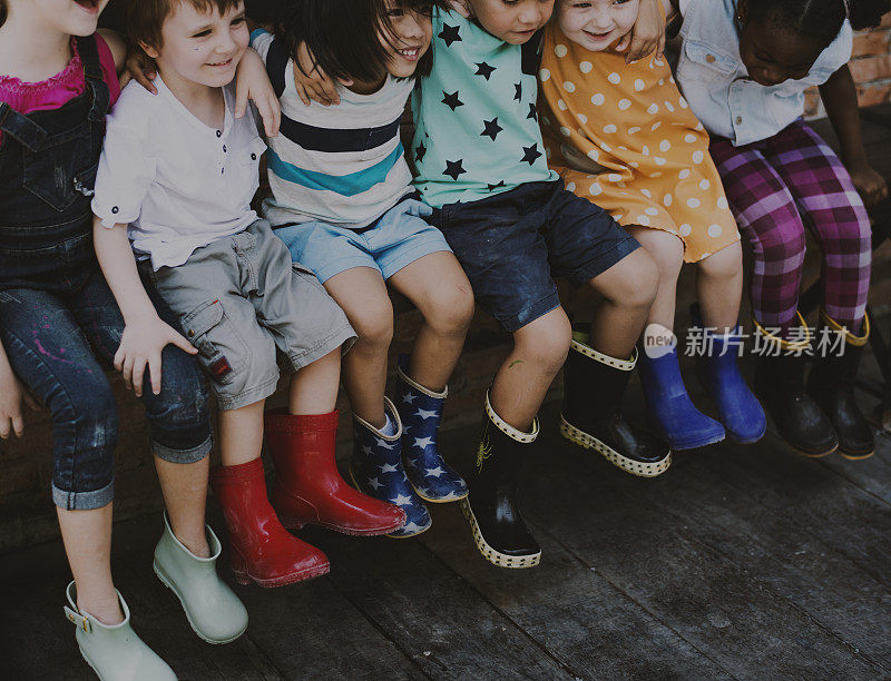 一群幼儿园小朋友朋友环抱而坐，笑口常开