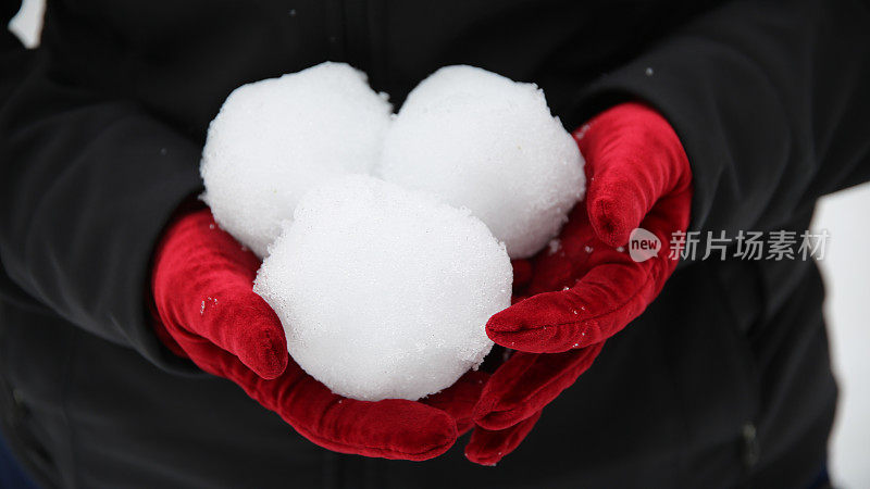 红色魅力天鹅绒手套拿着三个打雪仗雪球