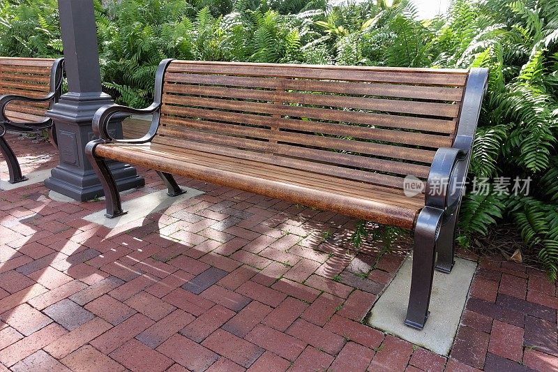 社区公园砖砌露台上的公园长椅。
