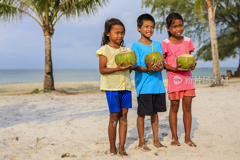 柬埔寨儿童在海滩上喝椰子汁，柬埔寨