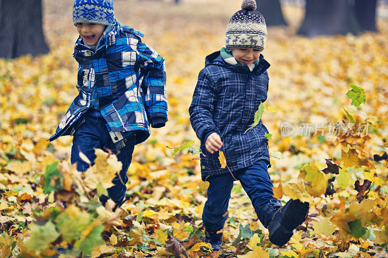 小男孩在秋天的公园里跑步