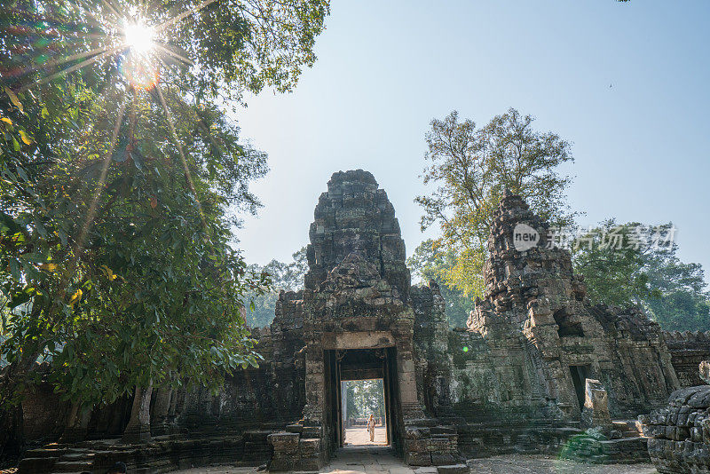 远处的旅游女游客站在寺庙复杂的大门前仰望上面的雕塑，人们发现探索的概念