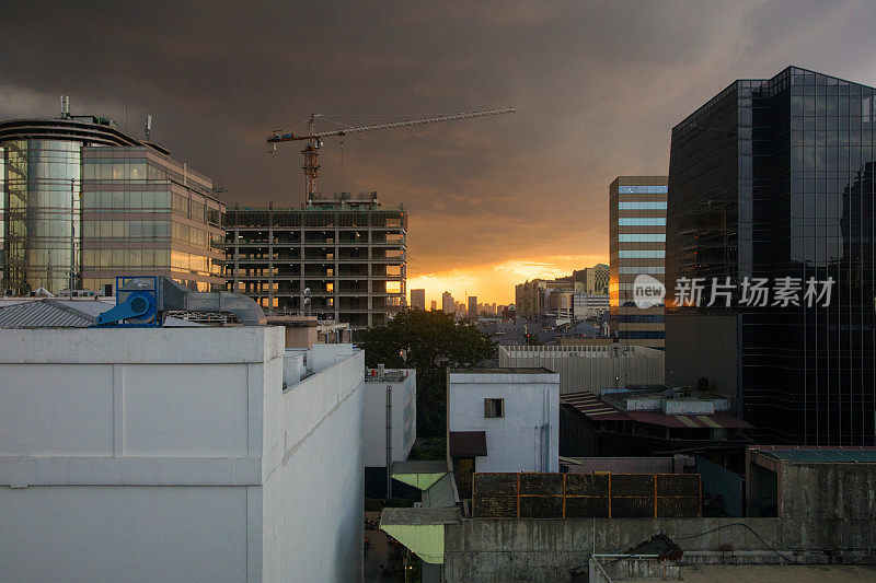 雅加达市中心空中天际线建筑工地和暴风雨的日落