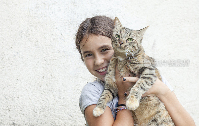 女孩抱着她友好的猫