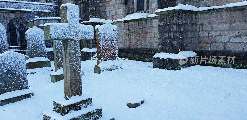 白雪覆盖的墓地里的坟墓、墓碑和墓碑