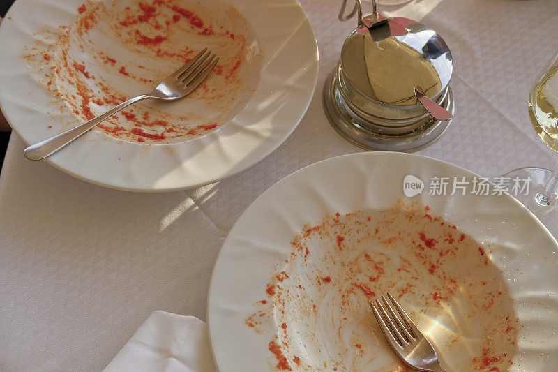 在意大利餐厅吃完饭后-空的意大利面，一罐帕尔玛干酪和一个酒杯