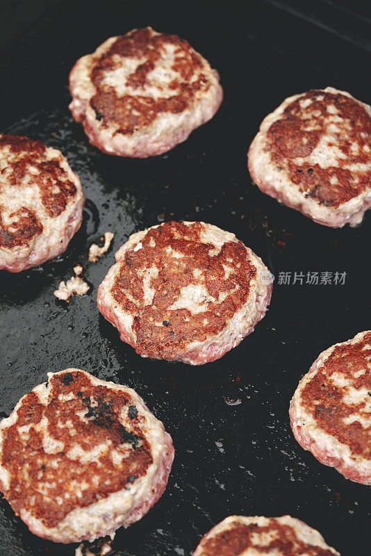 牛肉饼在烧烤架上准备汉堡