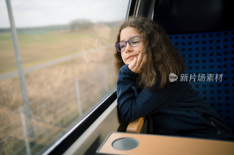 小女孩望着火车窗外