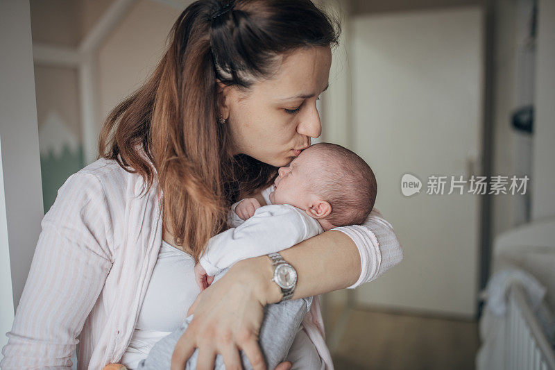 母亲在家里抱着她的男婴