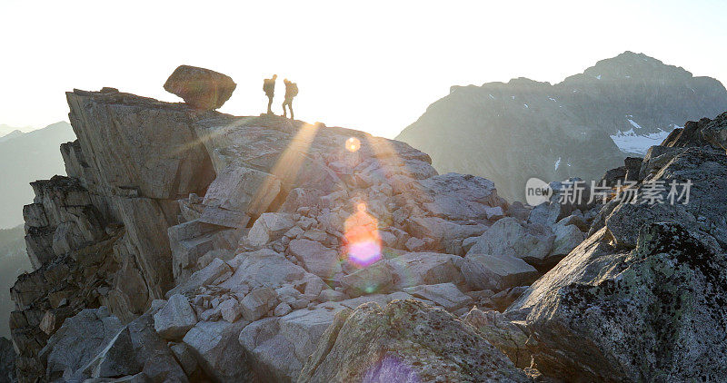 两名登山运动员在日出时横越山脊