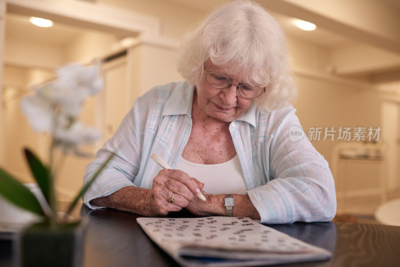 一位年长的女士正专注地解决她的填字游戏