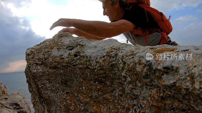 一个登山者横越岩石峰顶